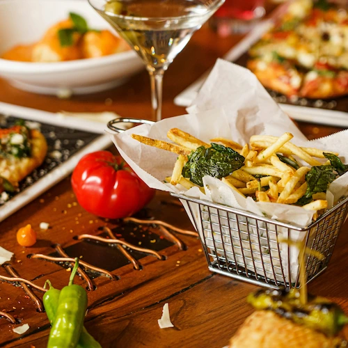 Savory Shoestring Fries surrounded with wine and foods on a table